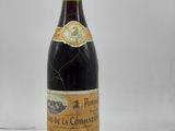 une bouteille de vin posée sur une table, devant un fond blanc