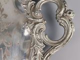 a silver vase with a handle on a wall