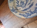 a blue and white plate sitting on a wooden table