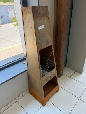 une étagère en bois sur laquelle est posé un ordinateur portable, devant une fenêtre