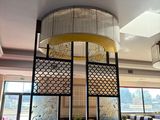 tables and chairs in a restaurant with a chandelier hanging from the ceiling
