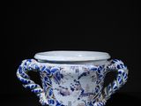 a blue and white cup with dragon handles