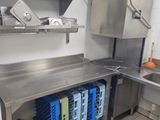 a kitchen with a sink, counter, and shelves in it