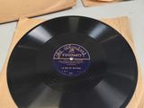 an old vinyl record sitting on top of a table next to other records
