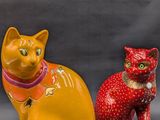 two figurines of cats sitting next to each other