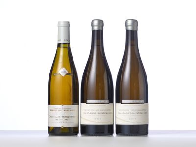 three bottles of wine are lined up on a table