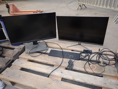 deux écrans d'ordinateur et un clavier posés sur une palette