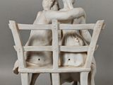 deux figurines représentant deux personnes assises sur un banc