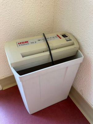 a white trash can sitting next to a white trash can