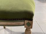 un gros plan d'une chaise verte posée sur un sol carrelé