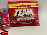 three toy firetrucks are sitting on a table next to each other