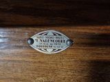 a close up of a wooden box with a metal label on it