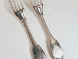 two forks that are sitting next to each other on a table