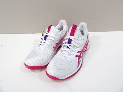 des chaussures de course blanches et roses posées sur une surface blanche