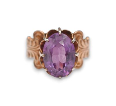 a close up of a ring with a purple stone in it