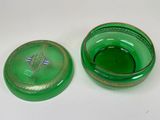 a green glass bowl with a lid on a white table