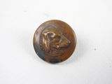 une image représentant un bouton en bronze orné d'une tête de chien