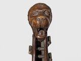 a close up of a wooden sculpture of a lion on a stand