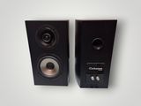 pair of black speakers on a white surface with a white background