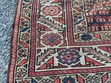 a red and blue rug sitting on top of a cement floor