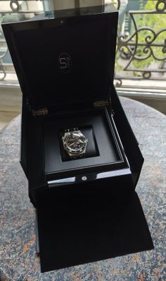 une boîte avec une montre à l'intérieur sur une table