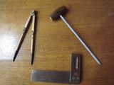 un marteau, un marteau et une paire de ciseaux posés sur une table