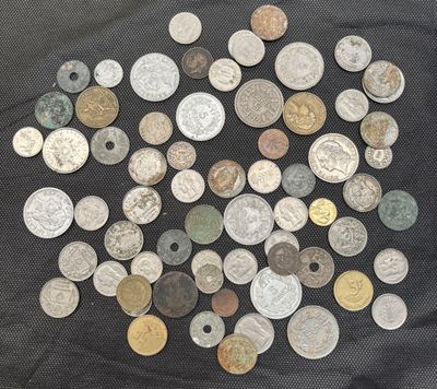 some of the coins are on a black cloth with a black background