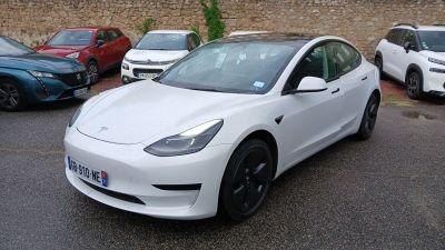 une Tesla Model 3 blanche garée sur un parking
