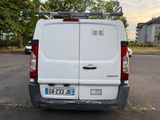 a white van parked in a parking lot with trees in the background