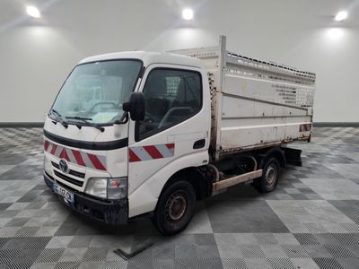 un camion blanc garé sur un sol à damier