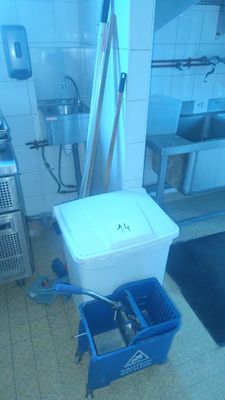 a blue bucket sitting in a kitchen next to a sink