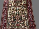an antique persian rug with a floral design on a white ground