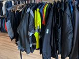 a lot of jackets hanging on a rack in a clothing store