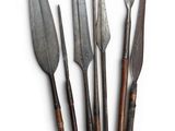 a set of five old knives with wooden handles on a white surface