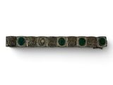 a close up of a metal object with green stones on it