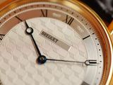 a close up of a gold watch with roman numerals on it