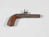 un gros plan d'un petit pistolet en bois posé sur une surface blanche
