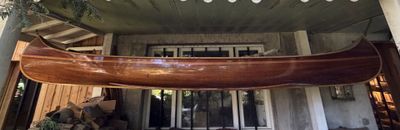 a large wooden boat hanging from the ceiling of a house
