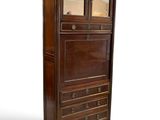 an image of a tall wooden cabinet with drawers and a glass door