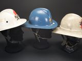 three hard hats that are sitting on top of a mannequin