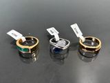 trois anneaux de couleurs différentes posés sur une table, accompagnés d'étiquettes