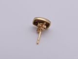 a close up of a small gold earring on a white surface