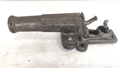 un gros plan d'un vieux pistolet posé sur une surface blanche