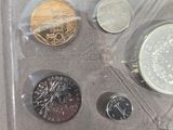four different coins in a plastic bag on a table