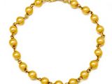 a gold beaded bracelet on a white background