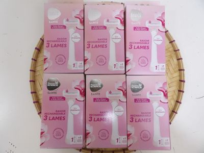 six boxes of pink and white toothbrushes sitting on top of a wicker basket