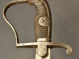 an old sword with a metal handle on a gray background