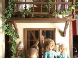 tout un tas de poupées qui se trouvent sur le balcon d'une maison de poupées