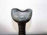 a black vase with a heart on it on a table