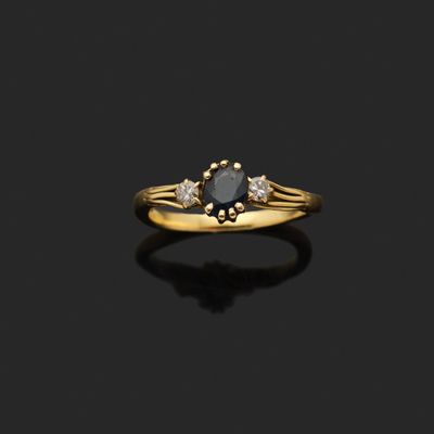 une bague en or sertie d'un diamant noir et de deux diamants blancs
